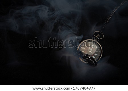 
Watch vintage pocket  with smoke on black background.