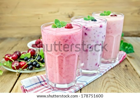 Milkshakes with black currant, cherry, raspberry in glass on the background of wooden boards Royalty-Free Stock Photo #178751600