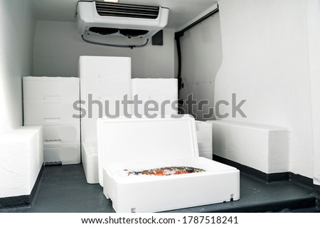White boxes with ice and fish loaded in van for transportation Royalty-Free Stock Photo #1787518241