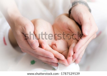 Sweet Family Joint Photo - Parents' hands holding the cute newborn's