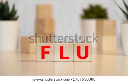 Alphabet blocks forming the word 'FLU' and viewed from the front and slightly to the left. The L block is tilted.