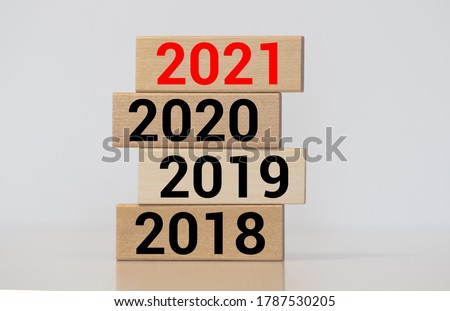 Businessman builds wooden blocks 2018, 2019, 2020, 2021. The concept of the beginning of the new year. New goals. Next decade. Trends and changes in the world. Build plans and planning. Time report Royalty-Free Stock Photo #1787530205