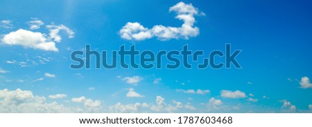 Blue sky background with tiny clouds. Wide photo.