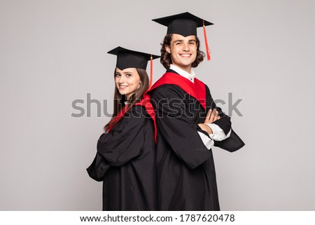 Portrait of two happy graduating students over white background. Royalty-Free Stock Photo #1787620478