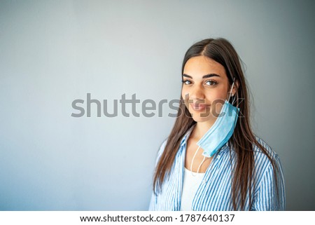 The woman show the wrong way to wear Hygienic mask. The girl incorrectly put on a protective mask. Protection from disease and virus. Disposable mask. Self-isolation protection. The woman smiles. Royalty-Free Stock Photo #1787640137