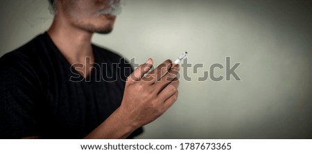 man holds cigarette behind the wall during smoking. illness concept.