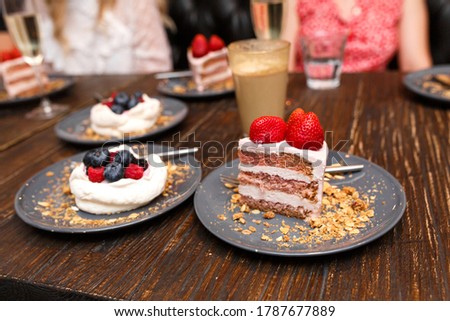 Sweet cakes with summer berries on a wooden table. Party, sweet table. Summer offer desserts in the restaurant