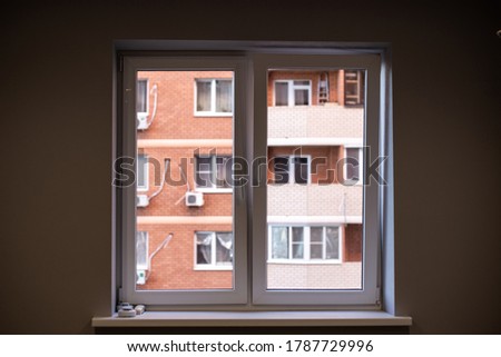 view from the window in a dark room to the street, to the brick house. The concept of loneliness, depression, isolation. Problem and solution Royalty-Free Stock Photo #1787729996