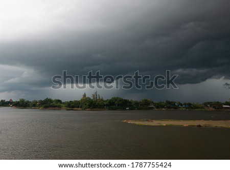 Nimbostratus clouds over the river and forest Royalty-Free Stock Photo #1787755424