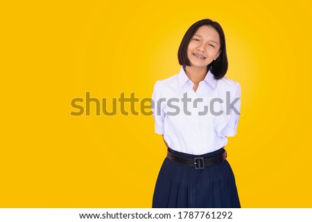 Asian student in uniform with yellow background.