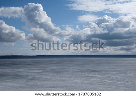 Landscape of iced Volga River and horizon in the early spring. Powerful clouds in sunny day.