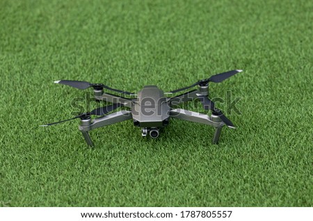 Drone copter with digital camera on grass floor .