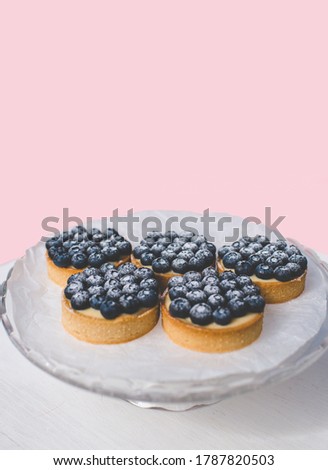 Sand basket with lemon cream and caramel. Decorated with fresh blueberries and powdered sugar.