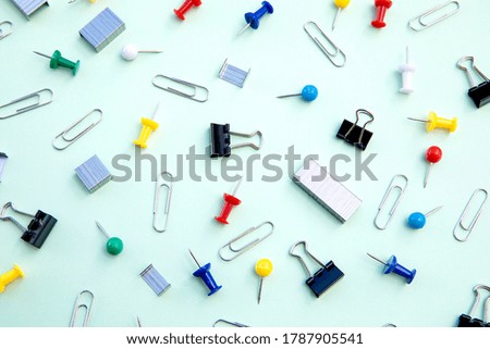 Stationery. Creative arrangement of items on a blue background: paper clips, clips, brackets, buttons.