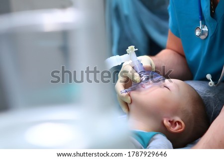 Preparation for dental surgery to remove multiple caries. Treatment of baby teeth. General anesthesia. The device of artificial ventilation of lungs.Copy space. Royalty-Free Stock Photo #1787929646
