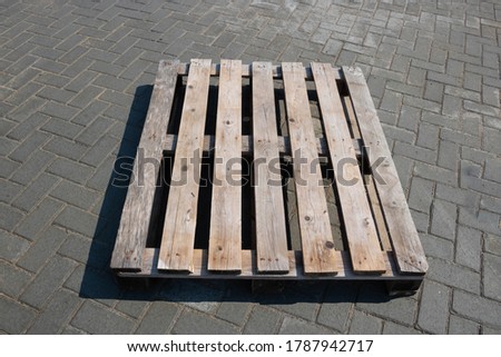 An old wooden pallet is lying on the sidewalk