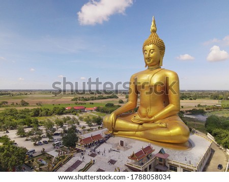 Gold buddha statue under construction in Thai temple with clear sky.WAT MUANG, Ang Thong, THAILAND.

