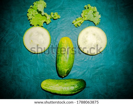 Sliced vegetable cucumber and zucchini on the kitchen table. Food photo. Cooking food. Home kitchen. Cucumber vegetable. Vegetarian food. Showcase advertising photo. Human face. Green salad.