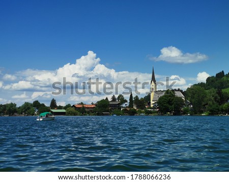 Beautiful seascape of lake Schliersee with an old church on a sunny day with blue sky in Bavaria, Germany