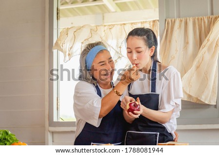 Senior asian mother and middle aged daughter cooking together at kitchen Royalty-Free Stock Photo #1788081944