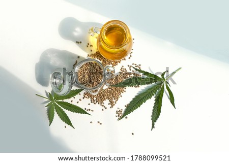 seeds hemp on the table, oil in a glass jar, cannabis leaves isolated on white background Royalty-Free Stock Photo #1788099521