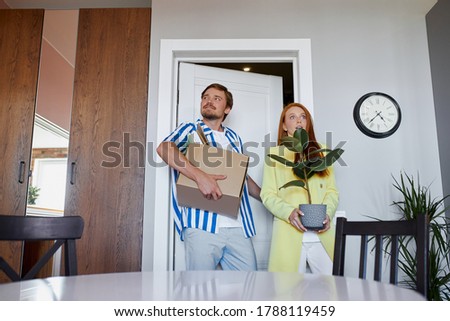 newly-made family moves to their own apartment, carry boxes and plants. relocation, house, flat concept Royalty-Free Stock Photo #1788119459