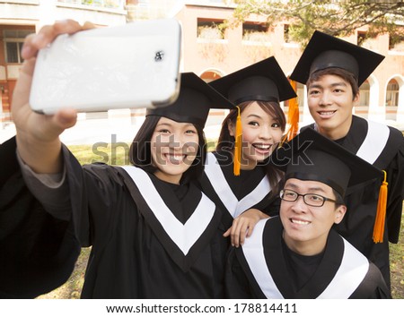 group of graduates  taking picture with cell phone