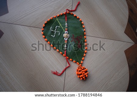 Rakhi band on a Ficus religiosa leaf with kumkum and rice. 