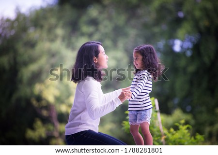 Portrait of a happy mother with her daughter in an outdoor public park, Asian girl lifestyle, Asian Mother's Day concept