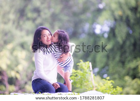 Portrait of a happy mother with her daughter in an outdoor public park, Asian girl lifestyle, Asian Mother's Day concept