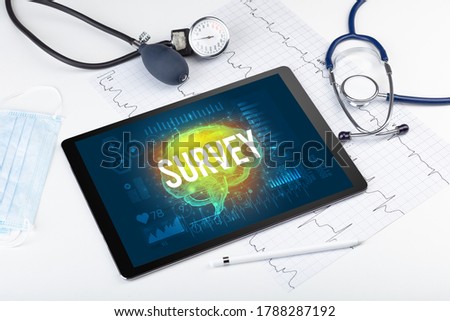 Tablet pc and medical tools with SURVEY inscription, social distancing concept