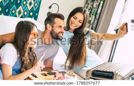 Beautiful young happy family making selfie photo in the bedroom and having fun together.