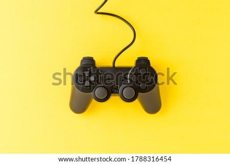 Black video game console on yellow background. Top view