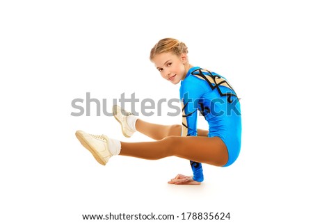 Young gymnast girl posing at studio. Professional sports. Isolated over white.