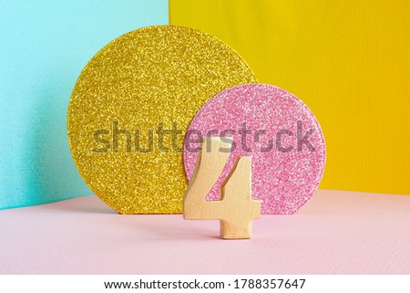 gold number "8" on a multicolored blue-yellow-pink background and two shiny gold and pink circles. happy birthday greeting card concept.
