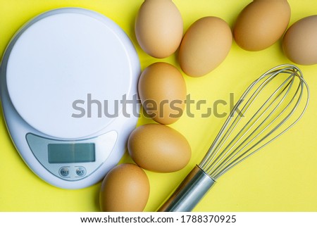 Chicken eggs, brown eggs, broken egg in carton box on yellow background. Top view natural eggs in carton box product concept,