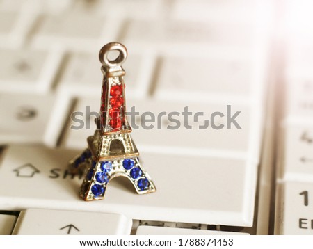 A statue of the Eiffel Tower in bronze on the laptop keyboard so close