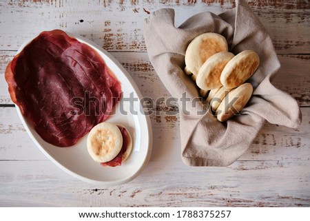 Typical Italian food TIGELLA on white dish with air-dried salted meat called BRESAOLA