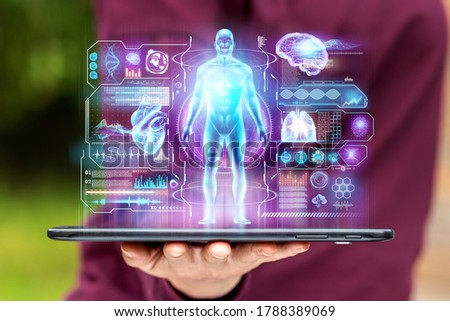 A tablet, map-case lies in the palm of your hand, on the hand is a close-up with various data in the form of a hologram. The concept of information, artificial intelligence, fast data
