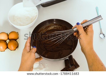 A woman mixing a bowl of chocolate cake mix