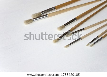Set of white brushes on a white background. Painting accessories.