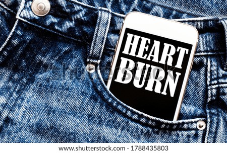 white phone with text Heart Burn lies in jeans pocket
