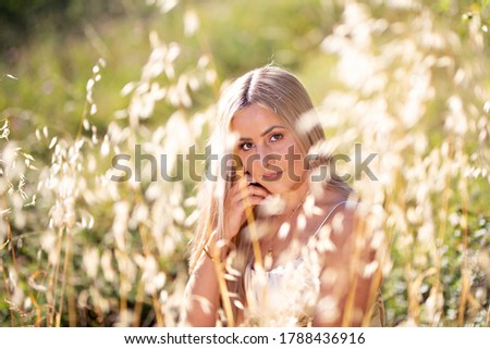 Portrait of a young woman sitting in the deep grass
