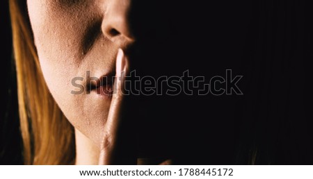 Seriouse woman placing her finger on lips - keep silence or secret. Mouth close up Royalty-Free Stock Photo #1788445172