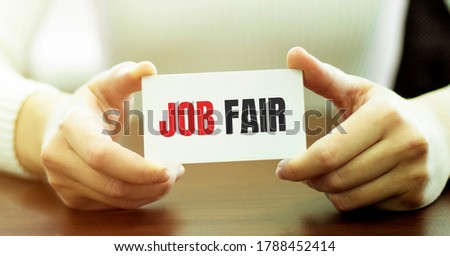 Businesswoman holding a card with text JOB FAIR, business concept