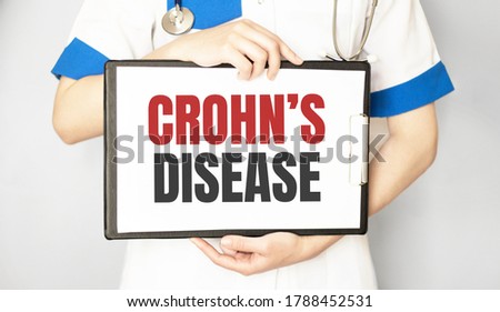 Doctor holding a paper plate with text Crohn disease, medical concept