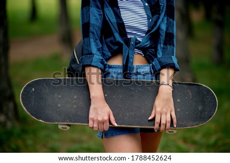 Close up of skater girl holding skateboard 