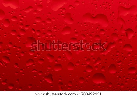 Water drops of different sizes on a red background