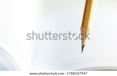 Closeup of sharp graphite pencil on white paper of notebook.  Concept of The National Day of Knowledge or International literacy day. Royalty-Free Stock Photo #1788507947