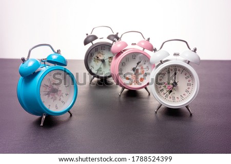 Set of beautiful new alarm clock on black leather pastel color colorful background